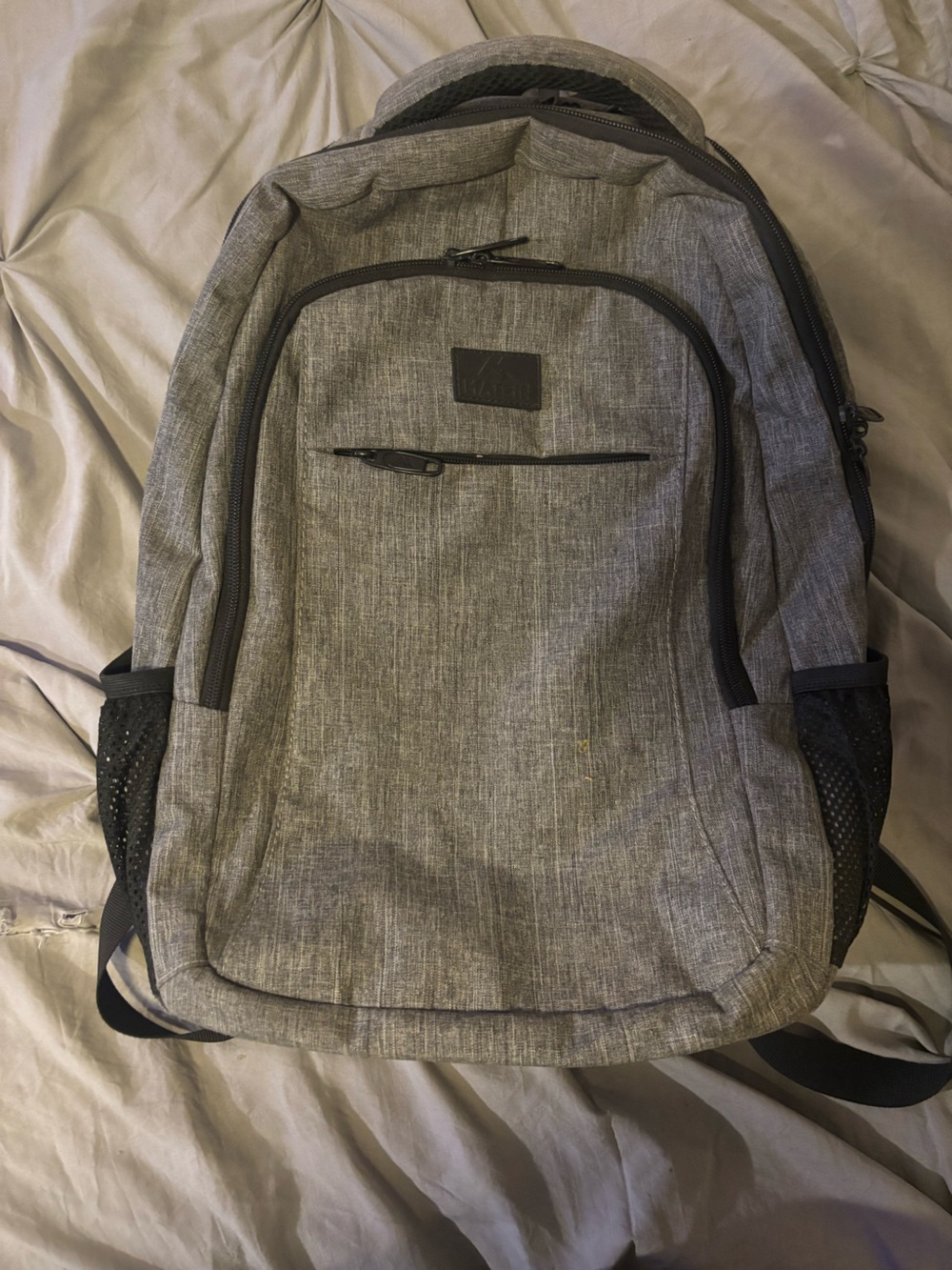 Gray Matein travel laptop backpack with mesh side pockets.